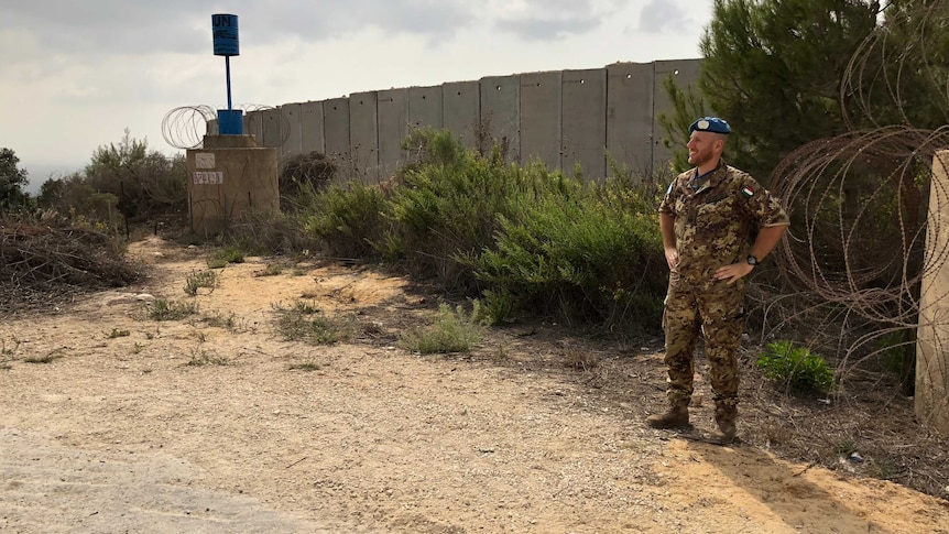 A guard stands at the Blue Line wall