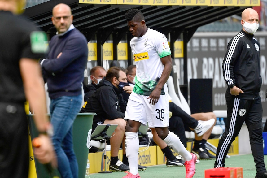 An African football player limps off the field