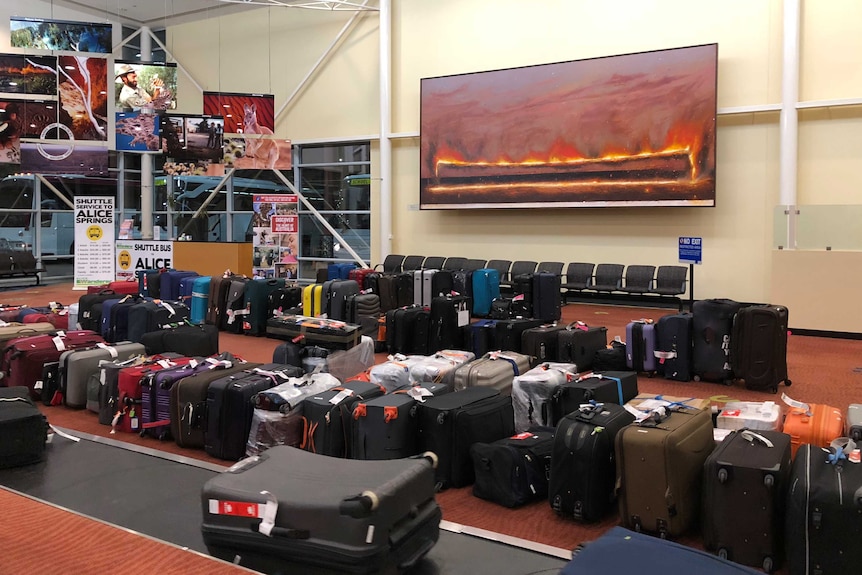 Dozens of bags laid out on the floor of Alice Springs airport.