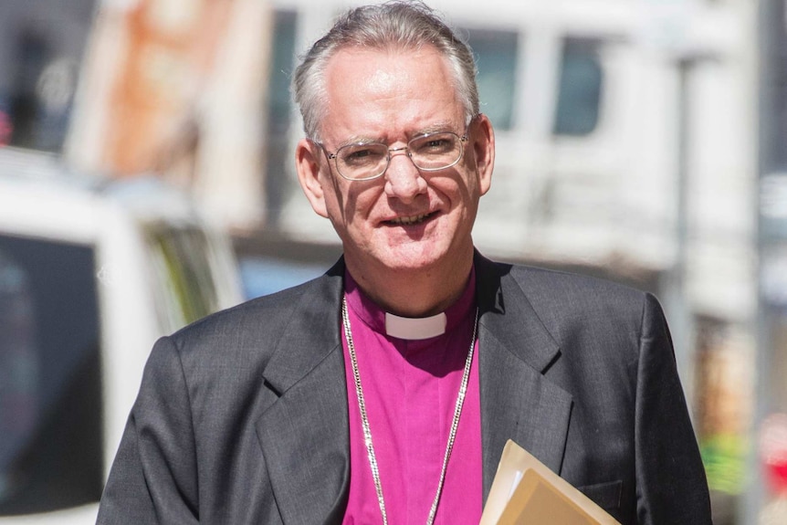 Front on photo of Archbishop of Brisbane Phillip Aspinall walking down a street on his way to the Royal Commission.