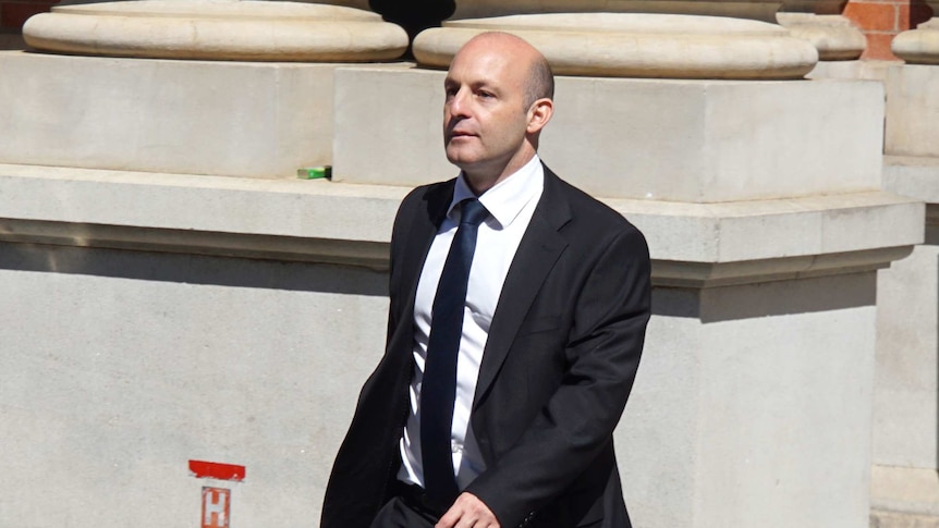 Male lawyer in black suit walking outside the Supreme Court building