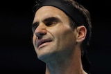 Roger Federer closes his eyes and opens his mouth in a grimace.