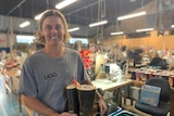 Ugg Director Todd Watts smiling holding ugg boots at Burleigh Heads factory