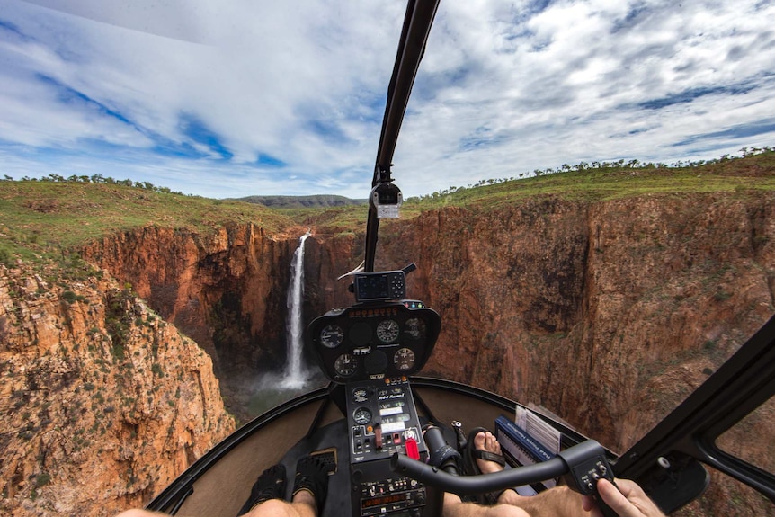 A photo of Revolver Falls taken from the inside of a helicopter.