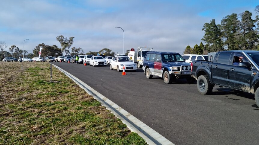 A photo of a line up of people in cars waiting for coronavirus testing.