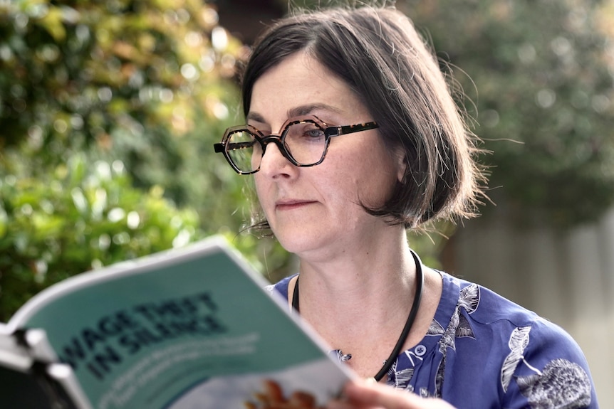 A woman reads a research paper.