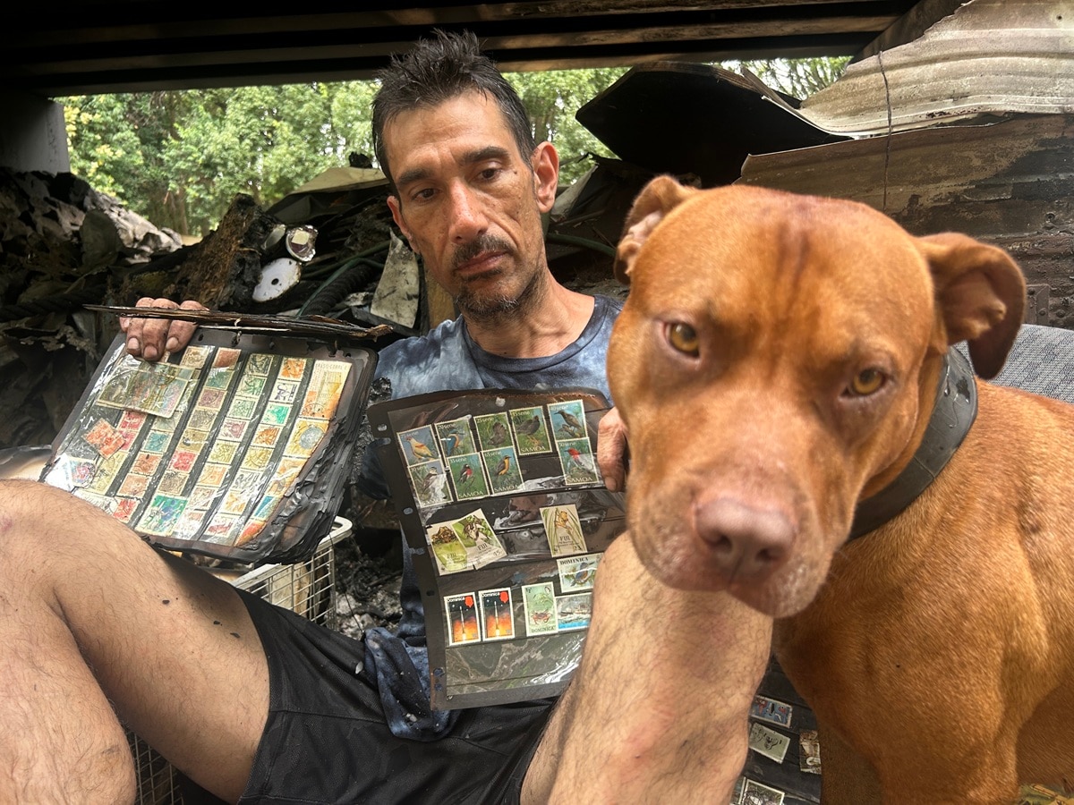 Hombre con álbum de sellos carbonizados y perro.