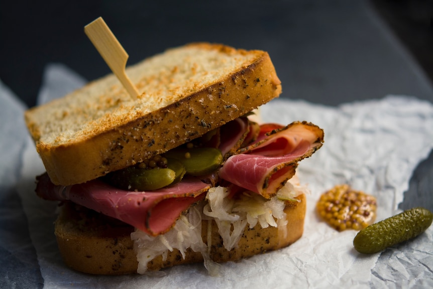 Toasted sandwich with cucumber pickles, sliced meat and sauerkraut.