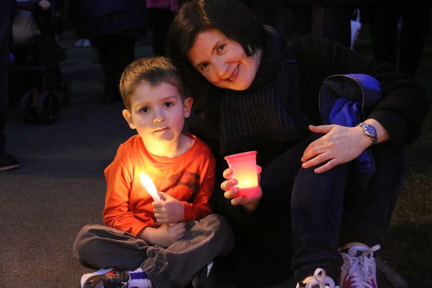 A mother and son at refugee vigil