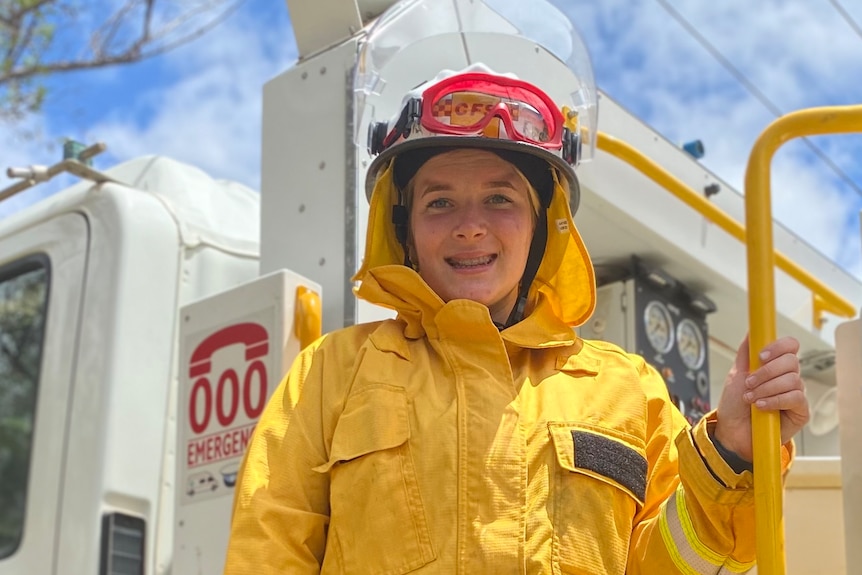 A young woman wearing protective gear standing on a CFS truck.