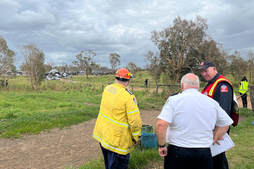 Emergency personnel look and point at contained fire 