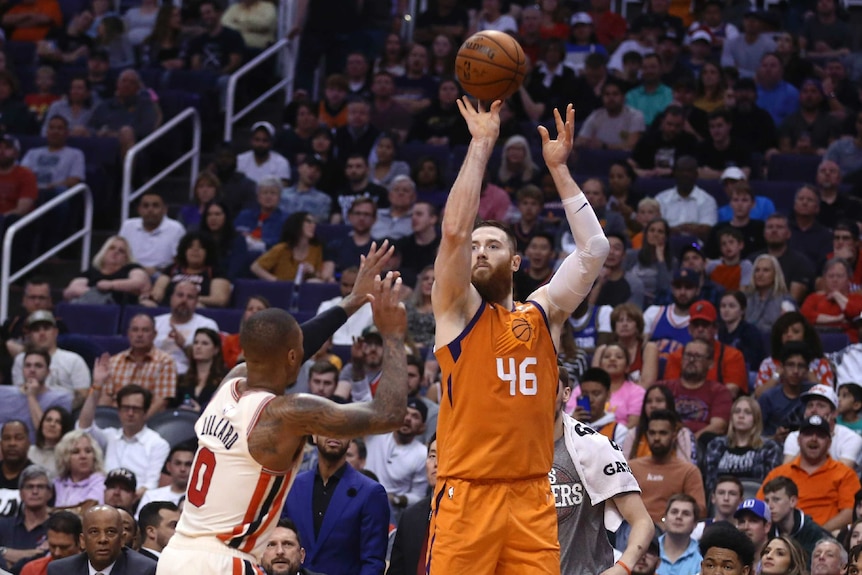 Aron Baynes releases a three-point shot while Damian Lillard contests.