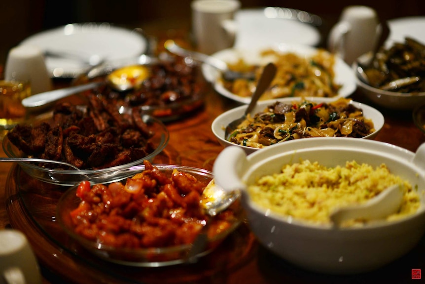 Plates with different dishes of Chinese food in them