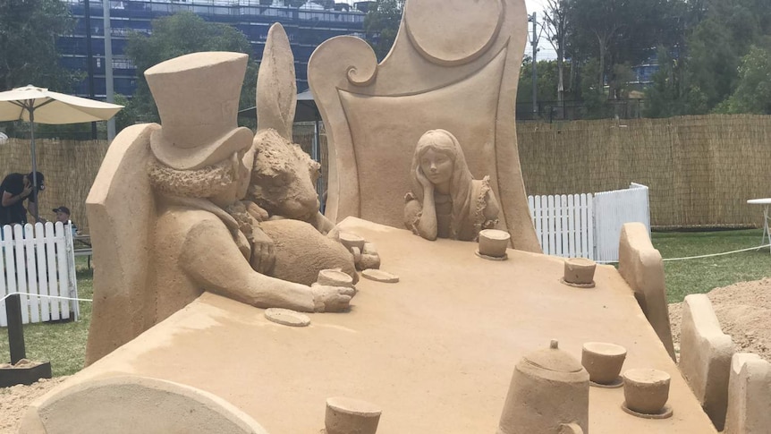 Two people made out of sand talking to each other.