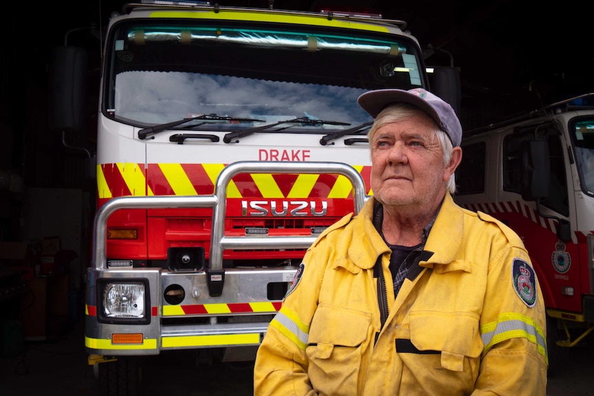 A man in RFS gears stands in front of a fire truck.