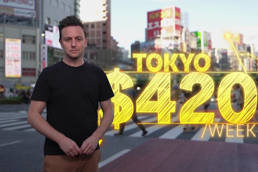 ABC reporter James Oaten next to a sign saying Tokyo