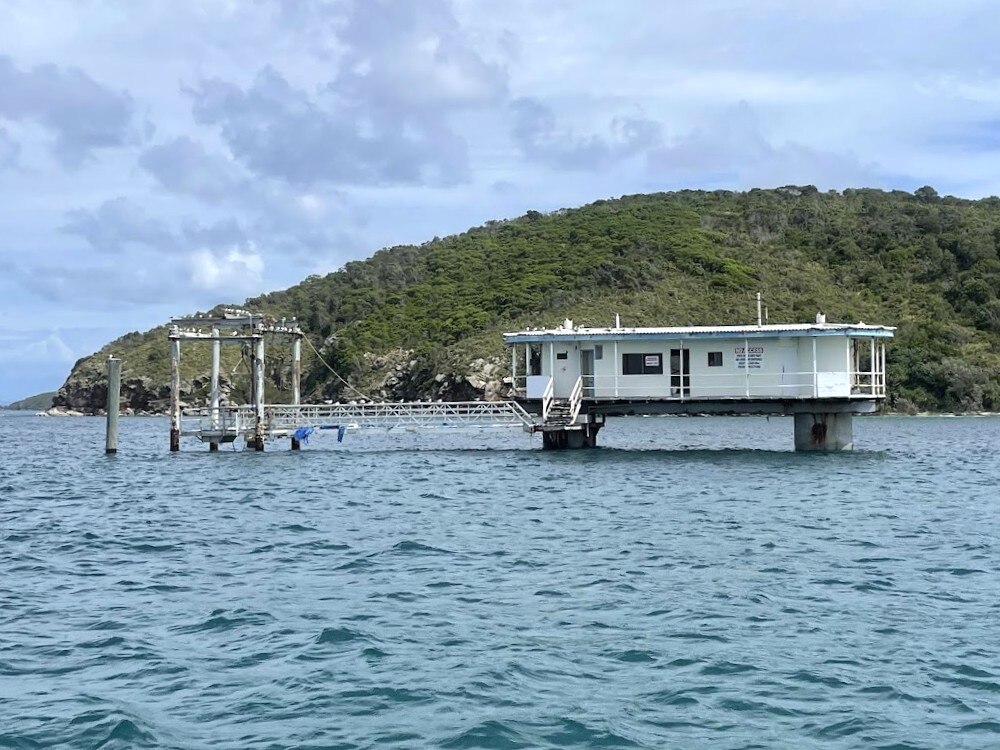 Um pequeno edifício que fica acima do oceano.