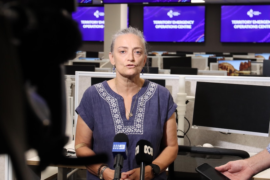 A woman with grey hair speaks at a press conference