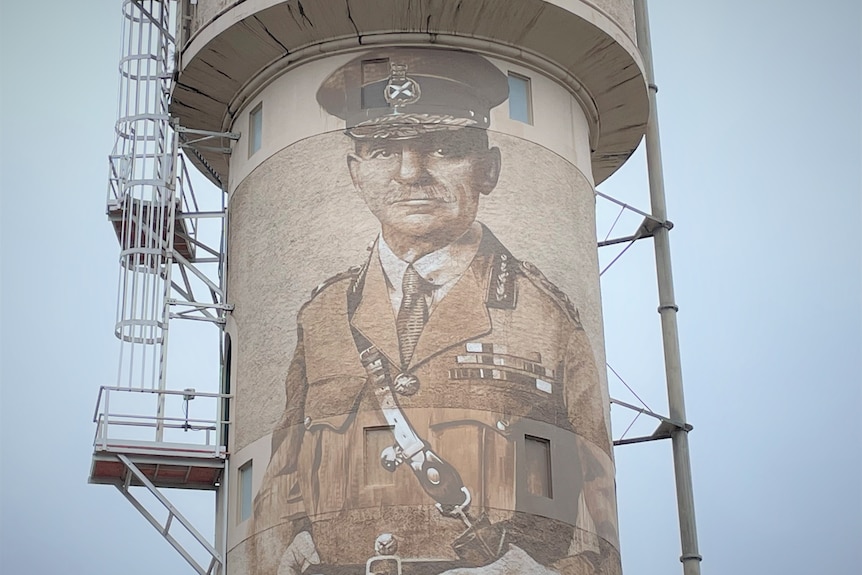 Water tower with man painted on it