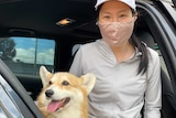 Lady in face mask with corgi
