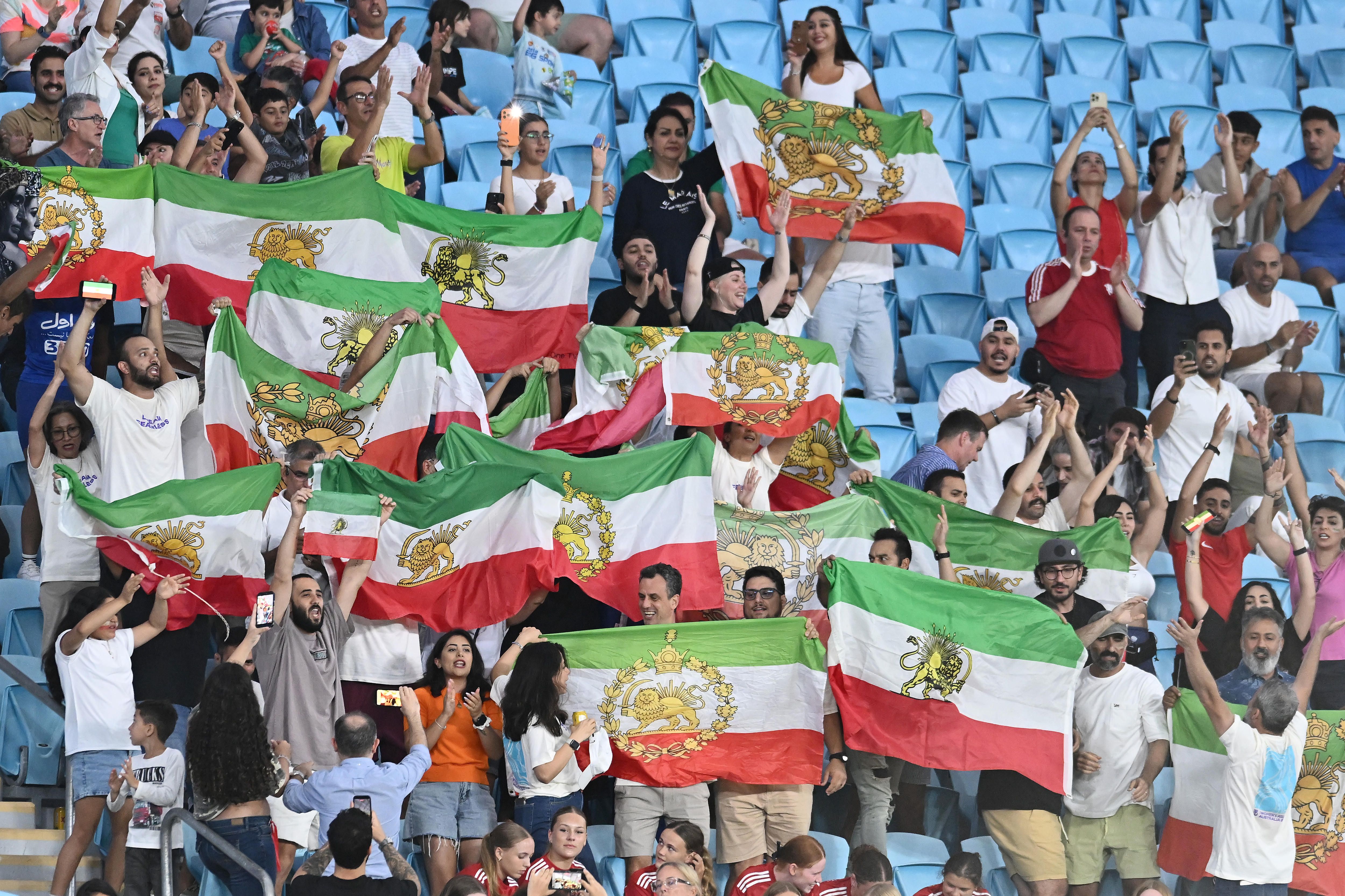 Torcedores de futebol seguram a bandeira iraniana “leão e sol” nas arquibancadas de um jogo da Copa Asiática Feminina