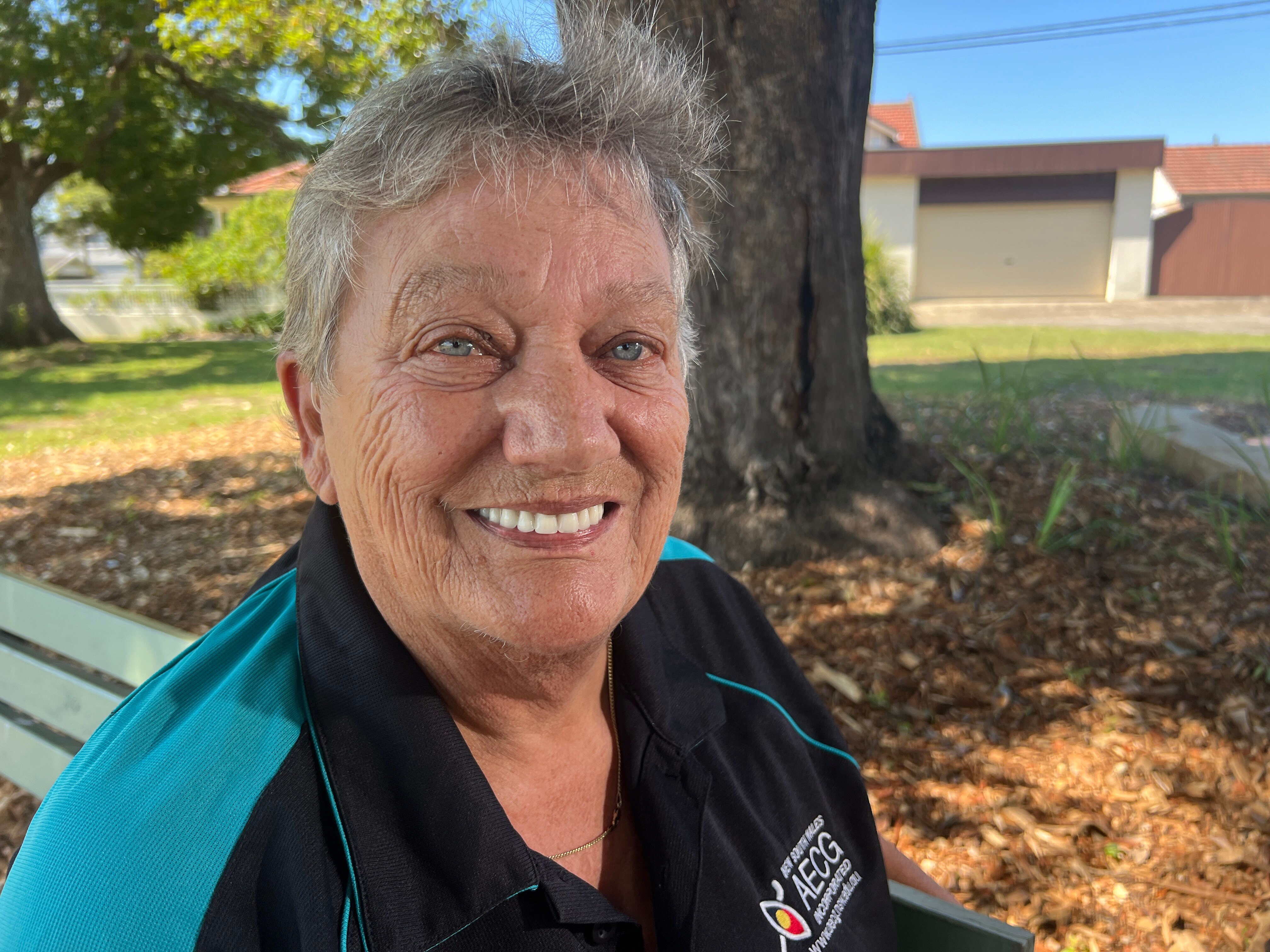 A photo of Aunty Lyn Martin. She has short white4 hair, blue eyes, and is wearing a blue top.