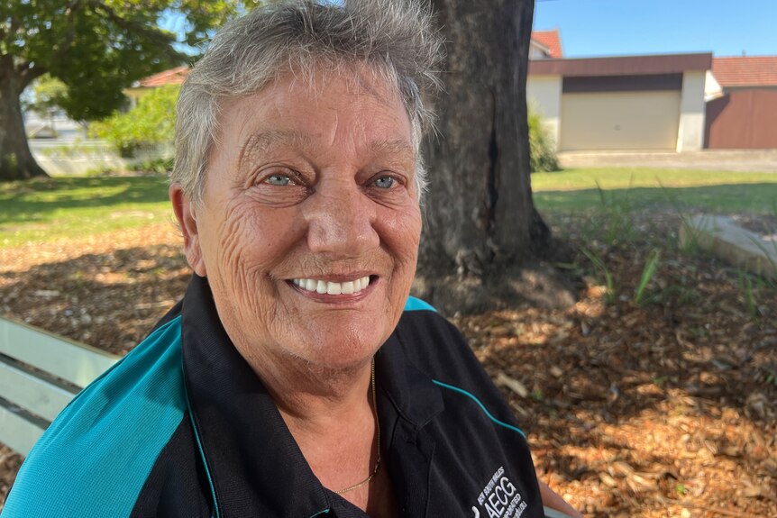 A photo of Aunty Lyn Martin. She has short white4 hair, blue eyes, and is wearing a blue top.