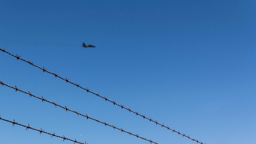 A jet plane flies over the Williamtown RAAF base.