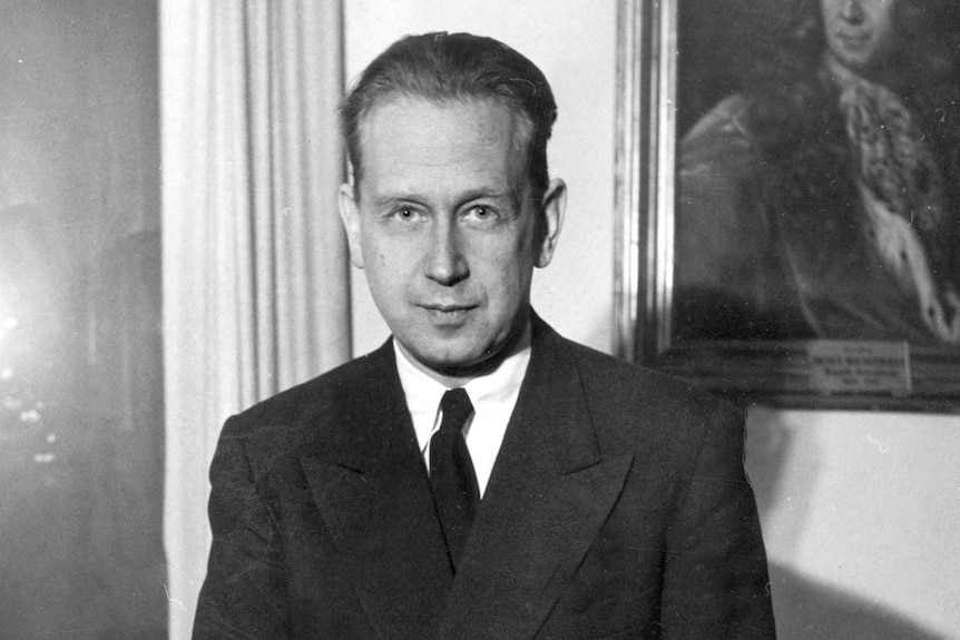 A black and white photo of Dag Hammarskjöld in a dark suit and tie