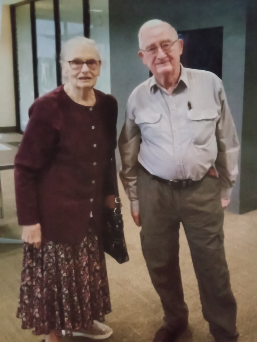 An old man and a woman standing next to each other.