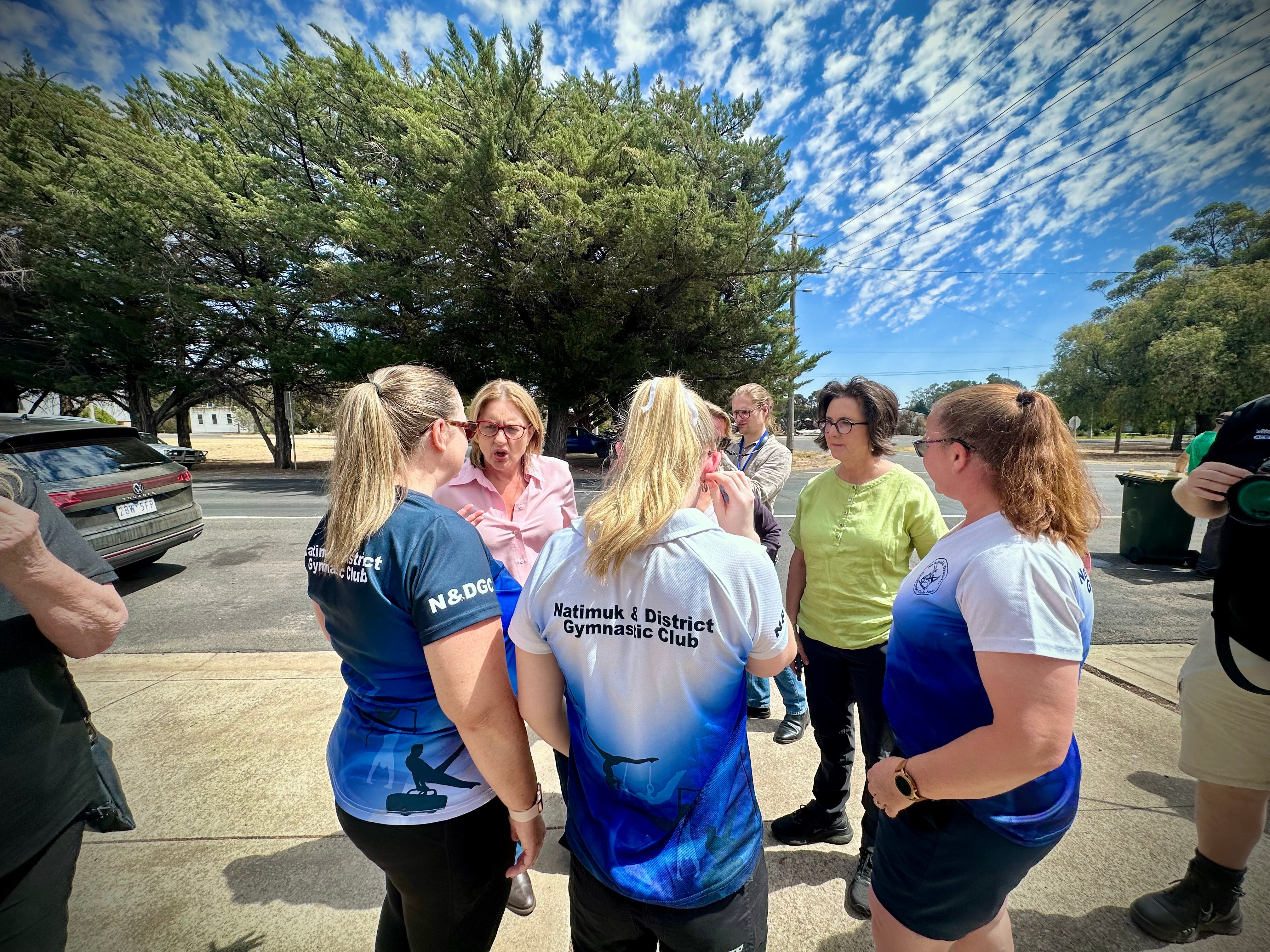 Jacinta Allan habla con tres mujeres con camisetas azules del club de gimnasia Natimuk.