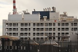 The live export ship Al Kuwait docked in Fremantle in the daytime with port cranes behind it.