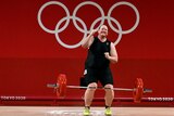 Lauren Hubbard smiles and punches the air after a successful lift in the women's 87kg weightlifting at the Tokyo Olympics. 