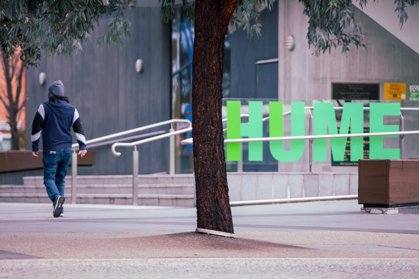 The city of hume sign is shown in green, a man is walking off to the side wearing blue.