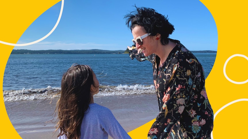 A woman and child hold hands on a beach for story on helping children accept their skin colour