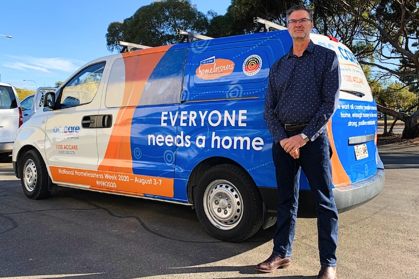 Man standing adjacent to a van with an ac.care logo on the side 