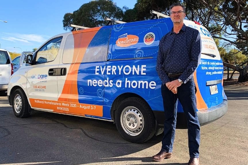 Man standing adjacent ac.care van.