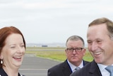 Julia Gillard laughs with John Key upon her arrival in Auckland