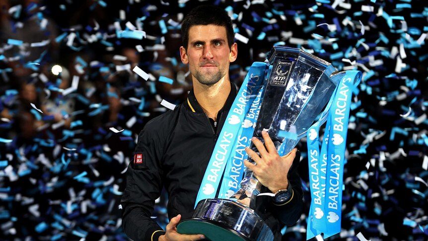Novak Djokovic celebrates with the trophy after claiming the ATP Tour Finals title