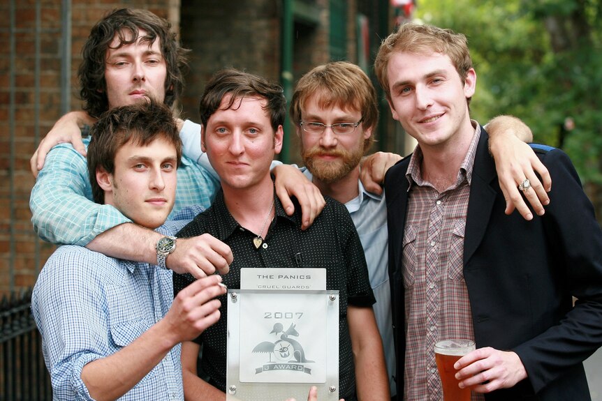 The five members of The Panics pose with the 2007 J Awards trophy, holding beers and smiling
