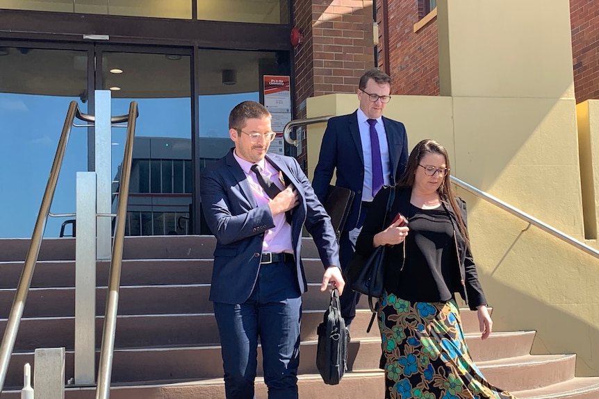 Workplace health and safety prosecutors walk down stairs of Mackay Court house. 