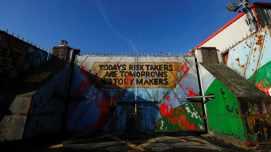 The words "Todays risk takers are tomorrows history makers" painted on the peace wall gate in Belfast, Northern Ireland