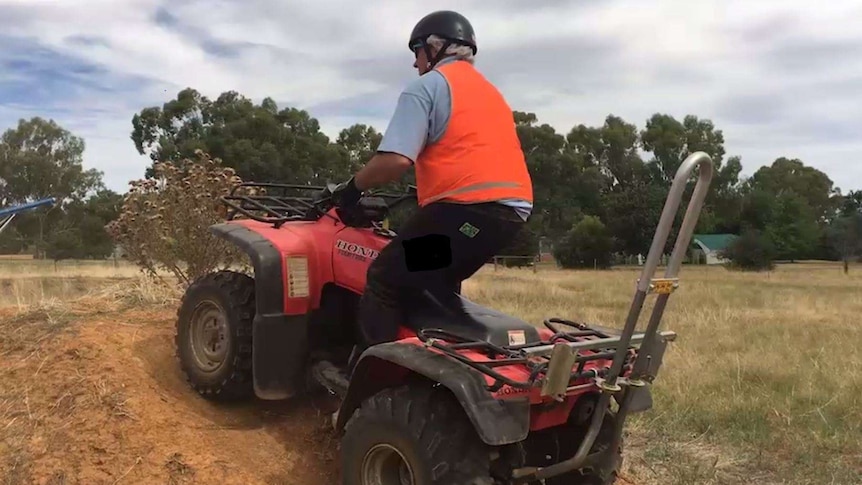 A participant in a quad bike training course learns how to safely navigate a small mound.