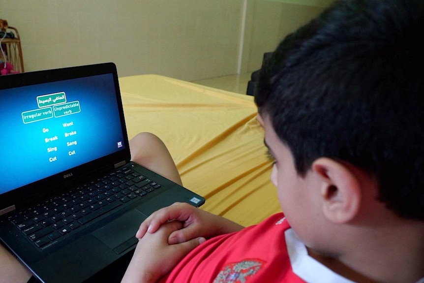 A child looking at a computer screen, doing an English language lesson