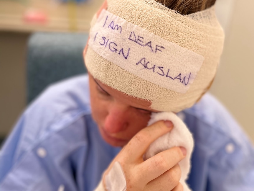 Hannah with 'I am deaf I sign in Auslan' written on a bandage around her head 
