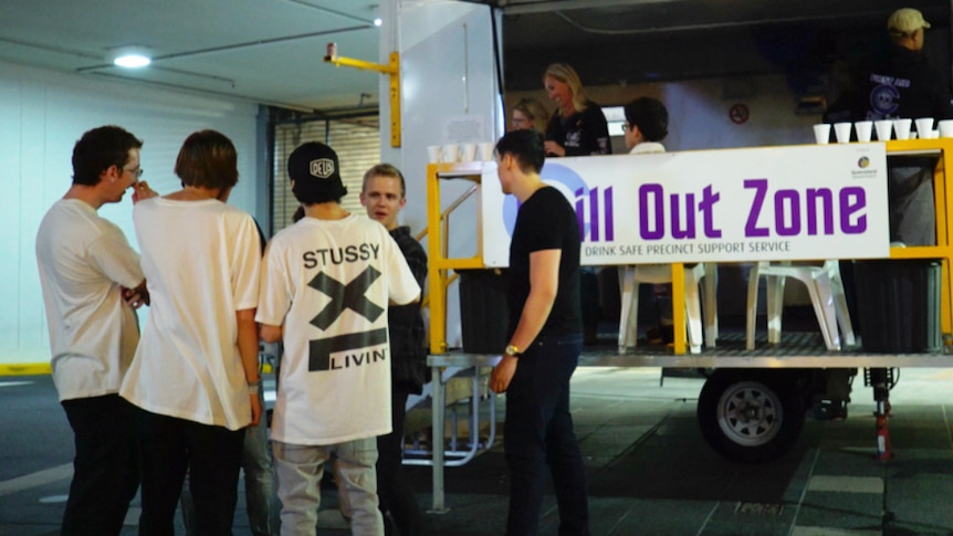 Group of young men standing outside a mobile caravan with sign that says Chill Out Zone.
