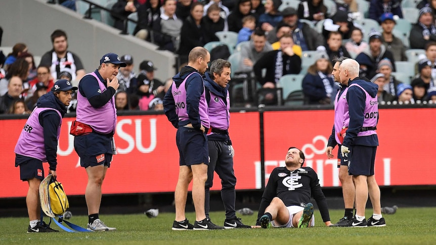 Carlton's Lachie Plowman (3L) is seen after sustaining an injury against Collingwood at the MCG.