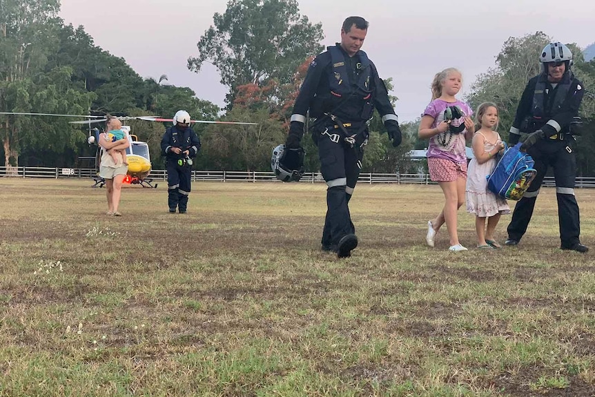 Chopper rescue crew on the ground with rescued women and children