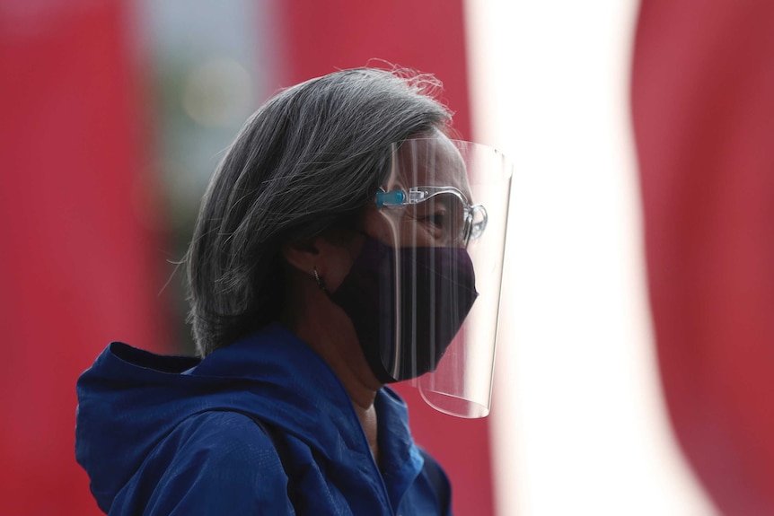 A woman wearing a face mask and shield