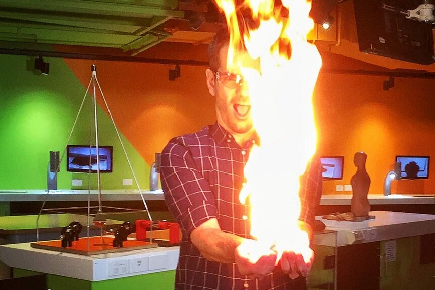 Nate Byrne performing a stunt where his hands are on fire.